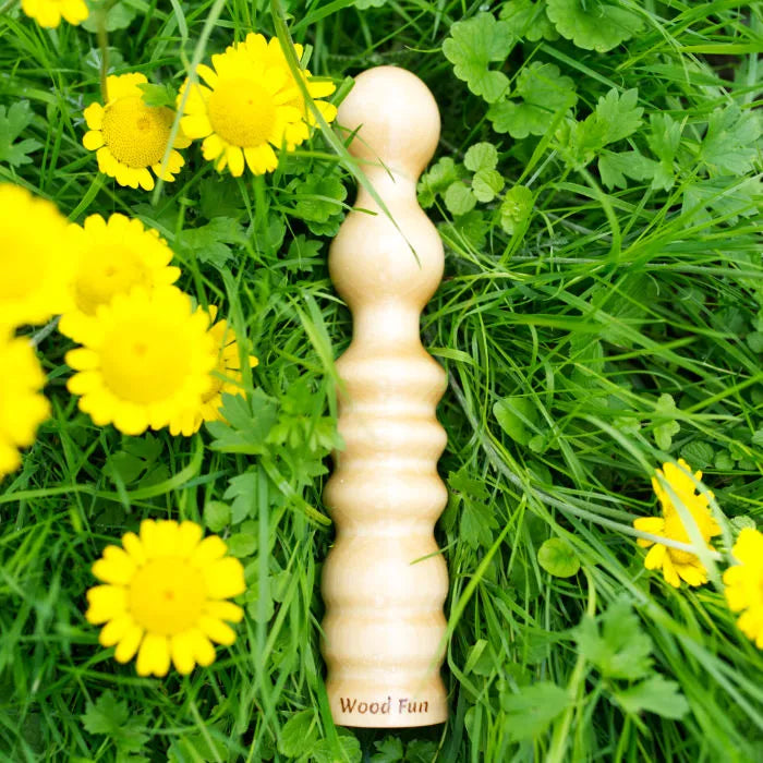 wood fun holzdildo sirene im gras neben blumen